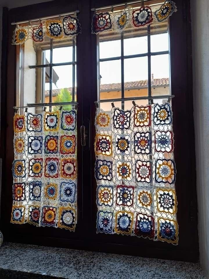 two windows with crocheted curtains on them in front of a window sill