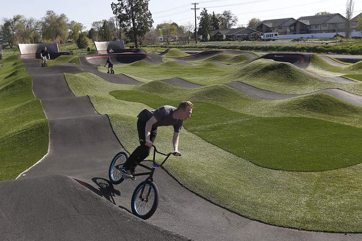 a man riding a bike down a hill covered in grass