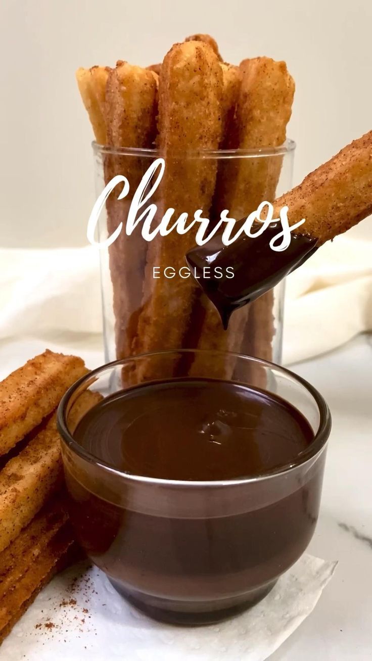 churros in a glass bowl next to some dipping sauce