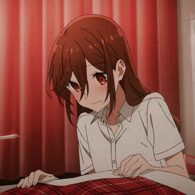 an anime character sitting in bed with red curtains