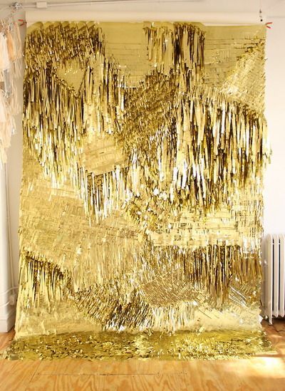 a large gold wall hanging on the side of a wooden floor next to a radiator