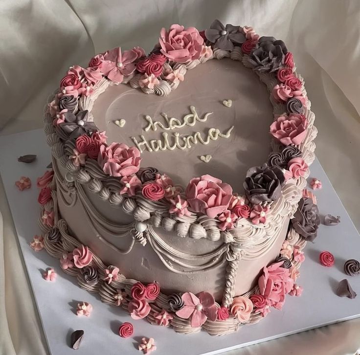 a heart shaped cake with pink and gray flowers