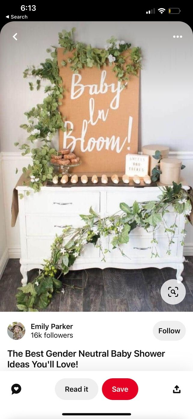 the best gender neutral baby shower sign is displayed in front of a dresser with greenery on it