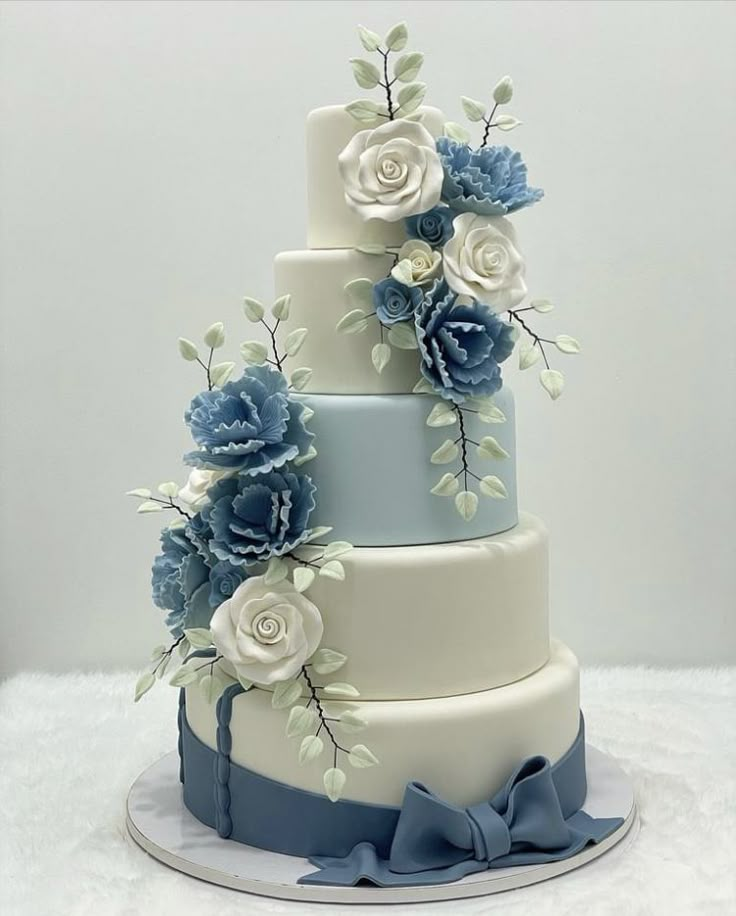 a three tiered cake with blue and white flowers