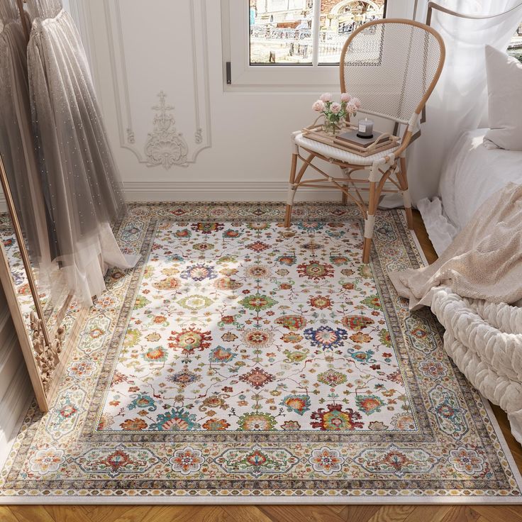 a room with a bed, chair and rug on the floor in front of a window