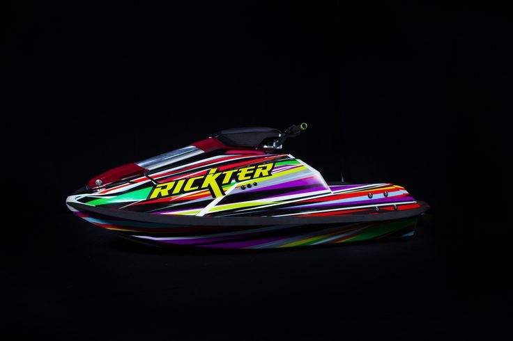 a colorful jet ski in the dark on a black background