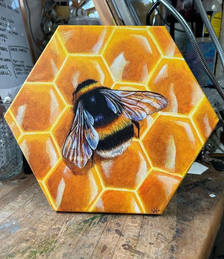 a painting of a bee sitting on top of a honeycomb that is painted orange and yellow