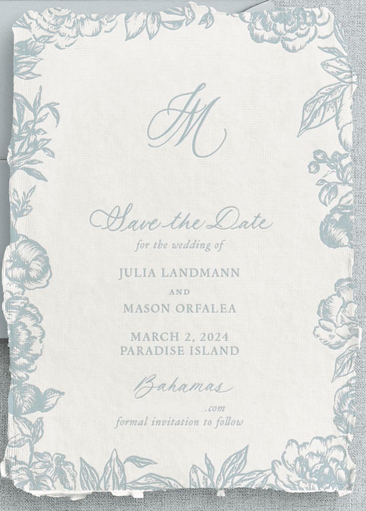 a wedding card with flowers and leaves on the front, in light blue ink that says save the date