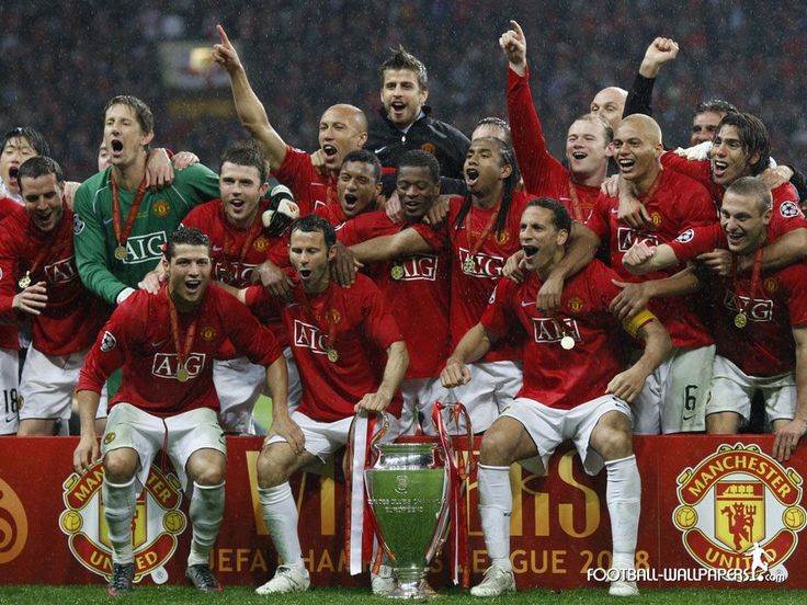 the manchester united team celebrate with the trophy