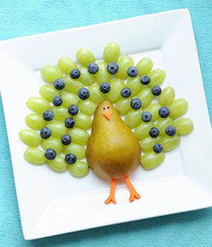 a plate with grapes on it and a turkey made out of grapes in the middle