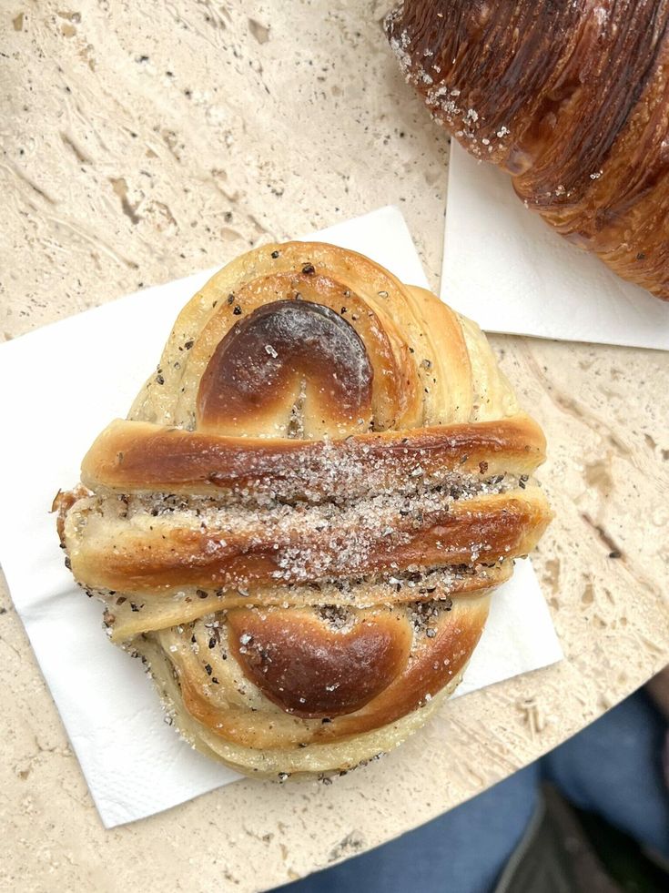 two loaves of bread sitting on top of each other next to a croissant