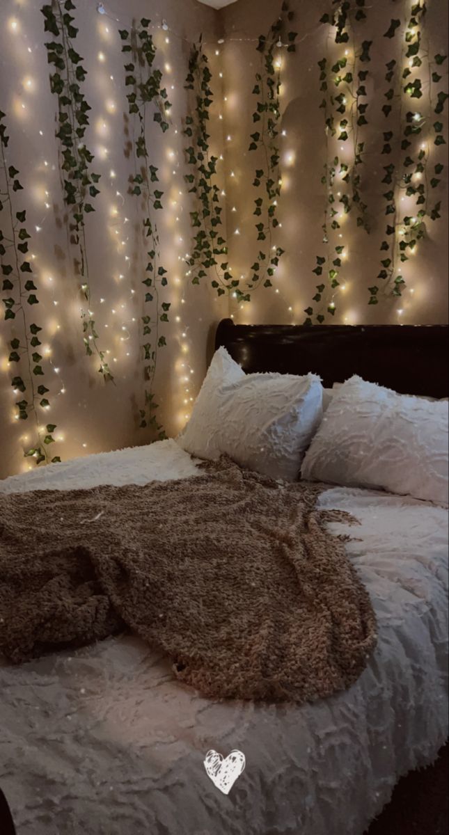 a bed that has some lights on the wall behind it