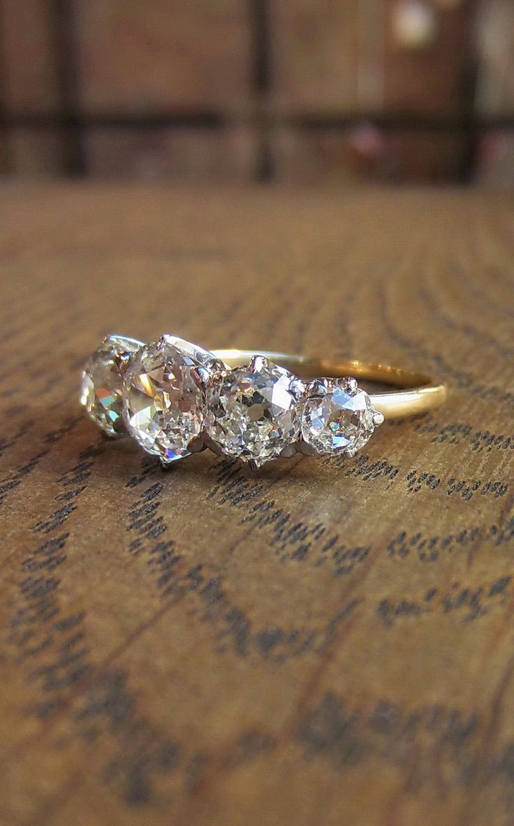 three diamond rings sitting on top of a wooden table