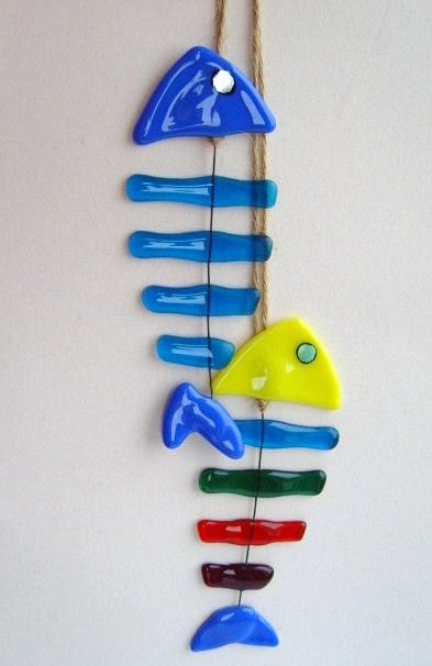 a wind chime hanging from a rope with colorful plastic fish on it's side