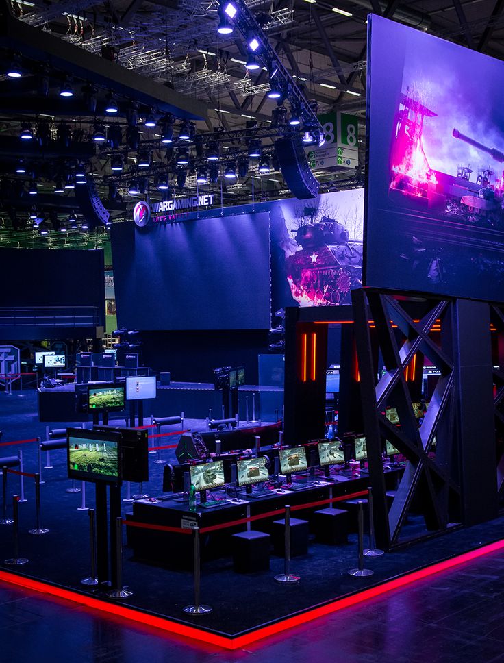 an exhibit room with large screens and video game equipment on display in front of them