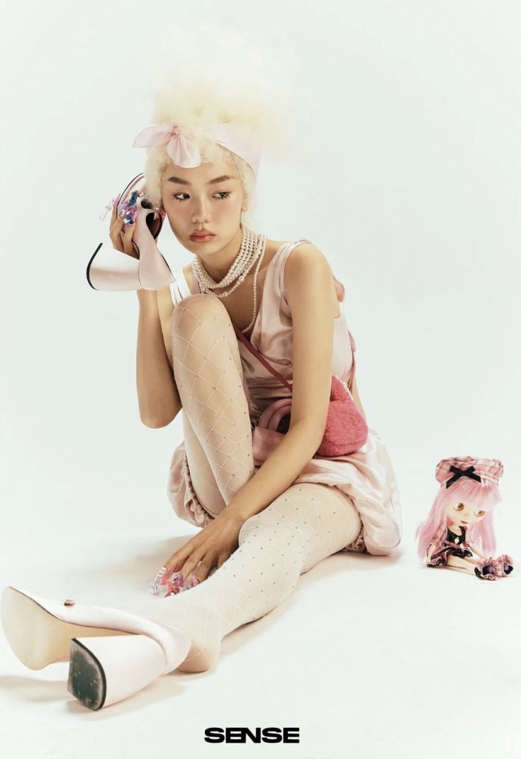 a woman sitting on the ground with her legs crossed and shoes in front of her