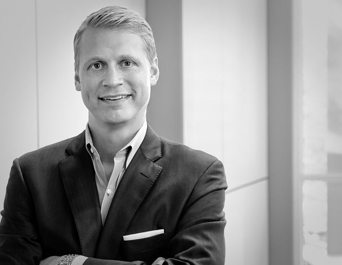 a man in a suit and tie standing with his arms crossed