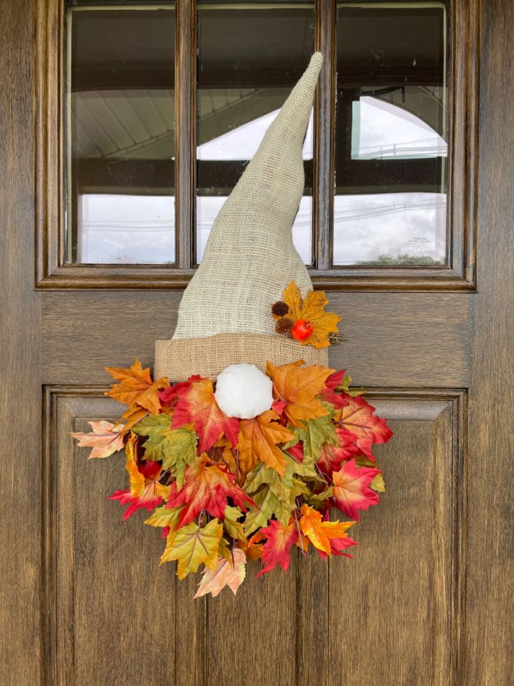 a fall wreath with a gnome's hat on the front door