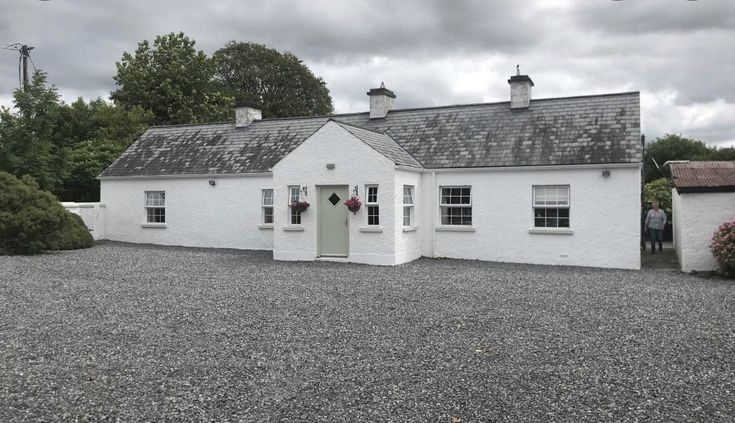 a white house sitting on top of gravel covered ground