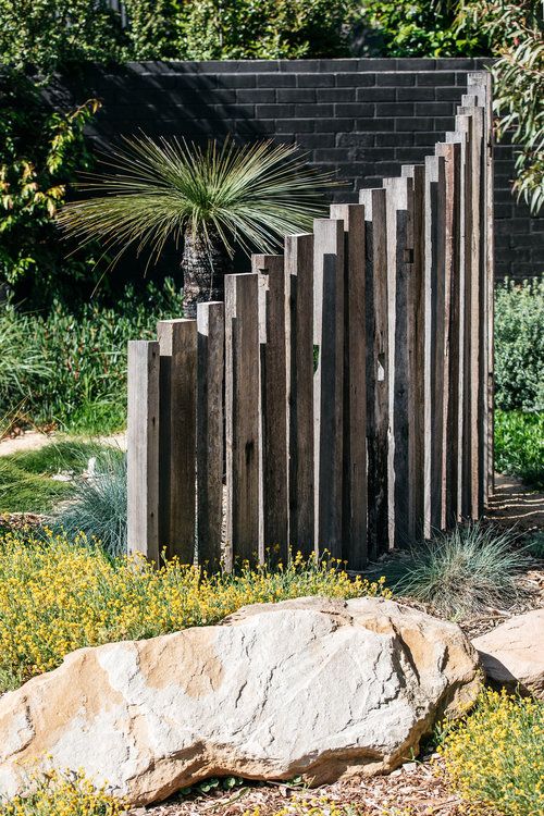 a wooden fence in the middle of a garden