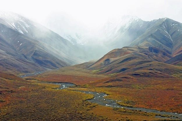 a river running through a valley surrounded by mountains