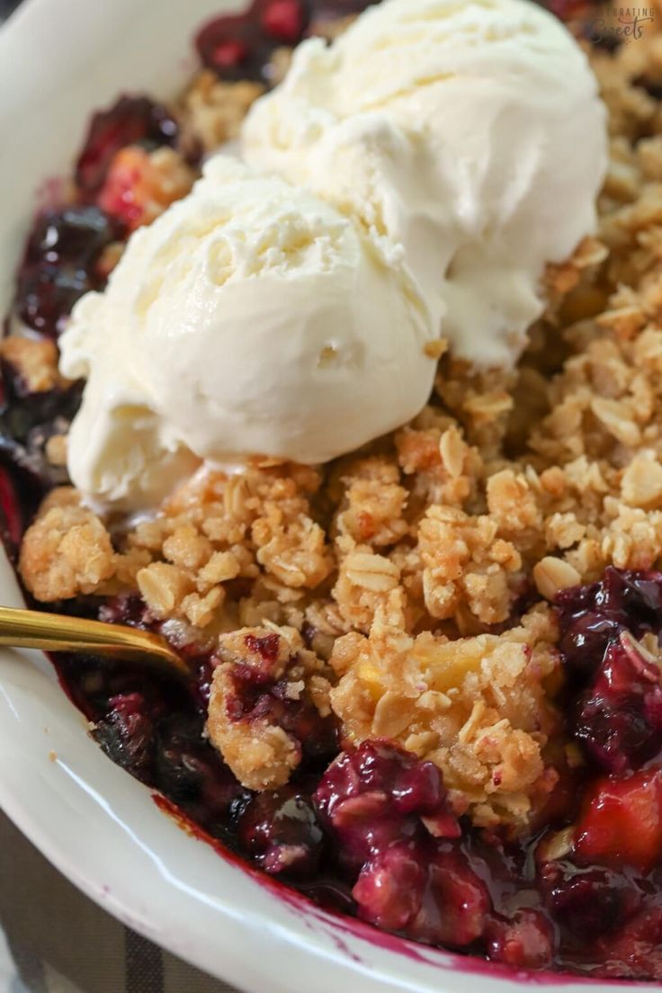 a close up of a bowl of food with ice cream on top and crumbled topping