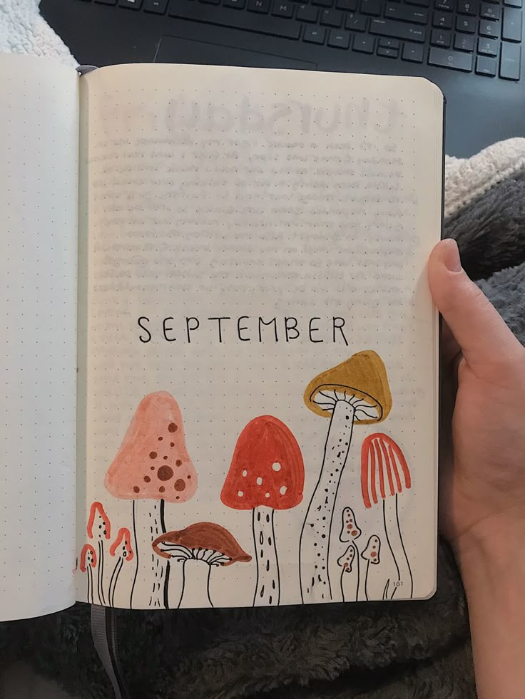 someone is holding up an open notebook with mushrooms on it and the words, september