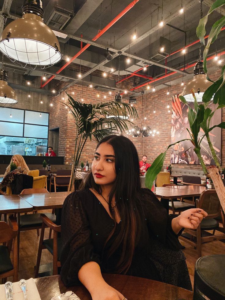 a woman sitting at a table in a restaurant