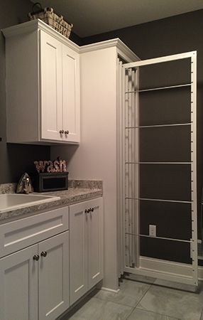 a bathroom with white cabinets and gray walls, along with a walk - in shower