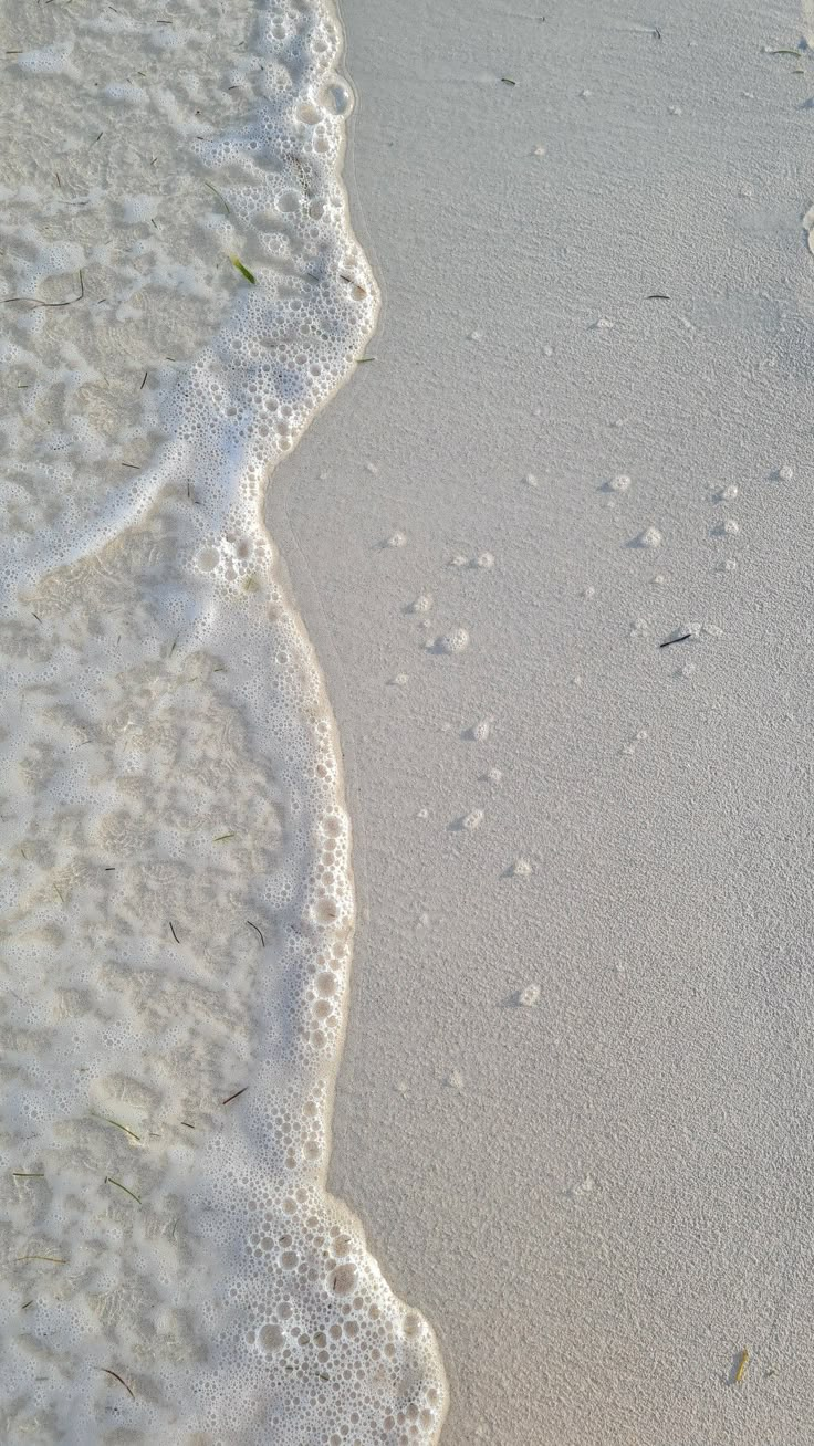 footprints in the sand and water at the beach