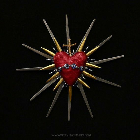 a red heart is surrounded by sticks and other metal objects in the shape of a star