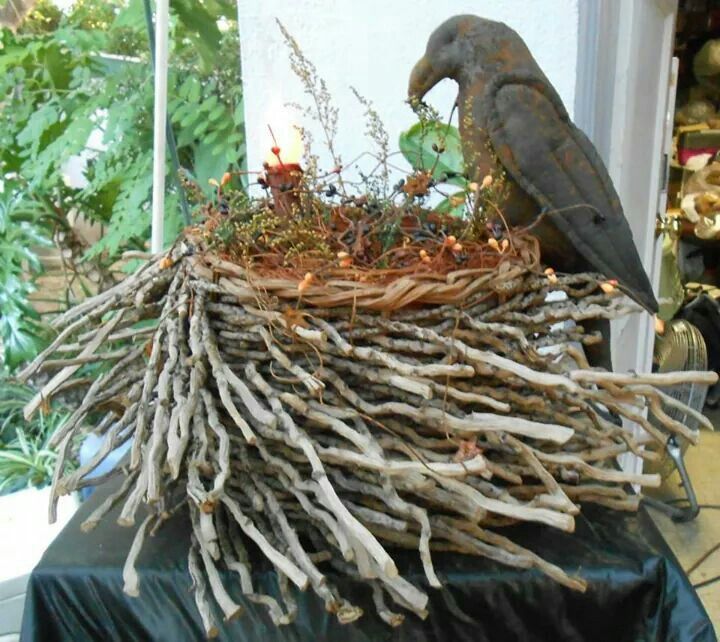 a bird sitting on top of a nest made out of branches