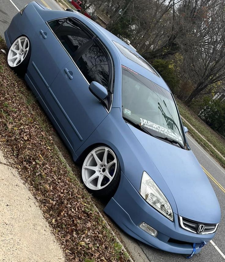 a blue car is parked on the side of the road