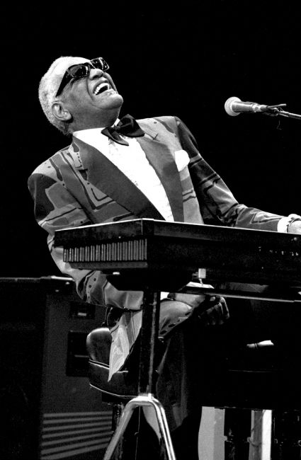 a man sitting at a keyboard in front of a microphone