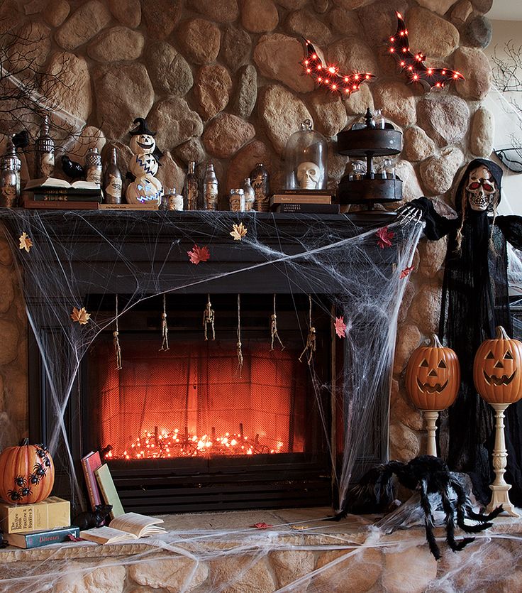 a living room decorated for halloween with pumpkins and decorations on the mantel,