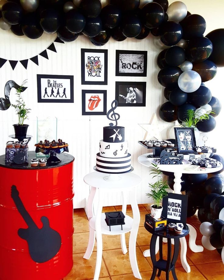 a party with black and white decorations and balloons