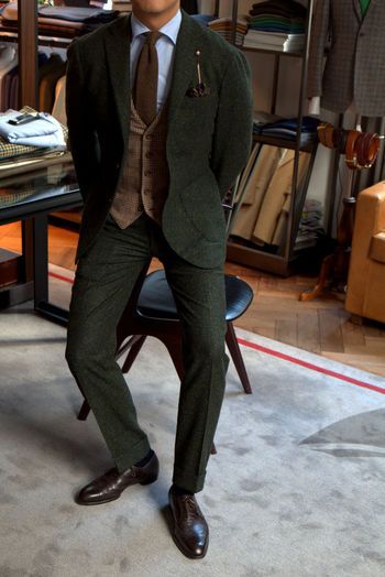 a man in a suit and tie is standing on the floor next to a table