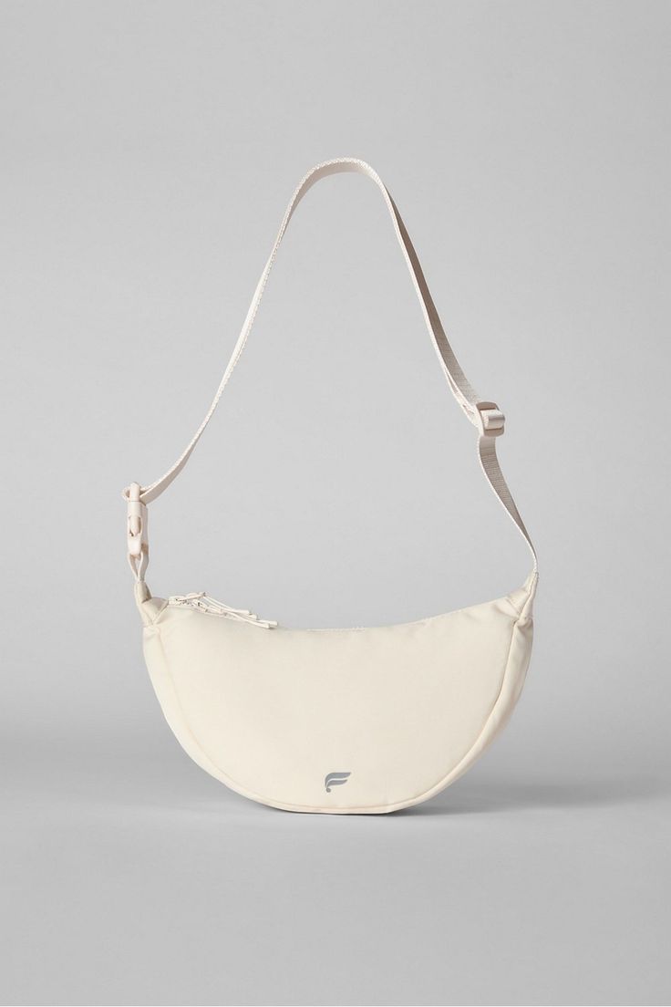 a white handbag on a gray background with straps and an empty bag in the foreground