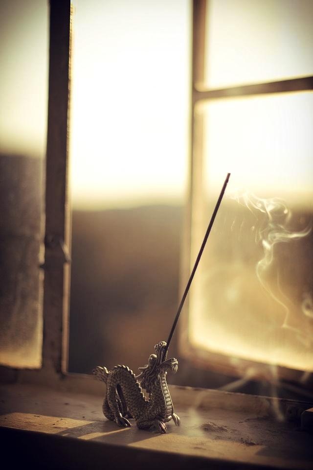 a incense stick sitting on top of a table next to a window