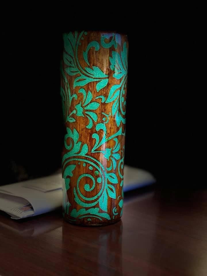 a close up of a cup on a table with a pen and notebook in the background