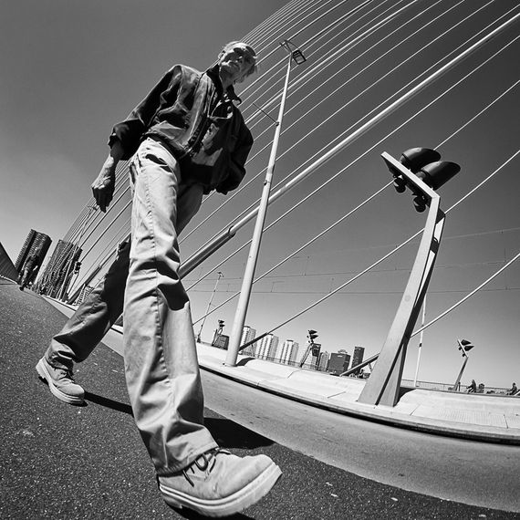 a man riding a skateboard down the side of a road next to tall poles