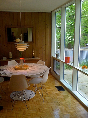 a dining room with wood paneling and glass doors leading to an outside deck area