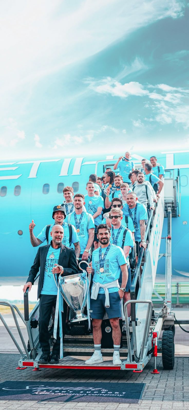 a group of men standing on the steps of an airplane