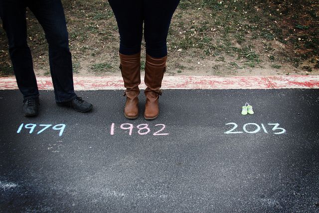 two people standing in the middle of a parking lot with numbers painted on it and trees behind them