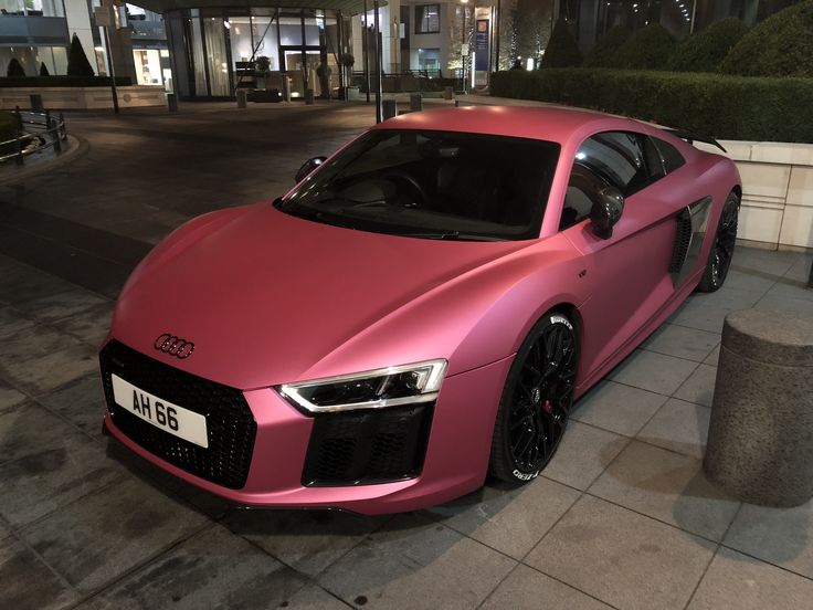 a pink car parked on the side of a street