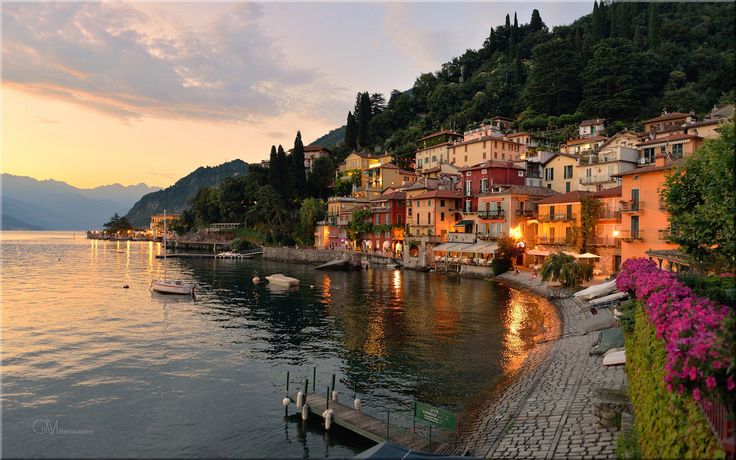 an image of a town by the water at sunset or dawn with boats in the water