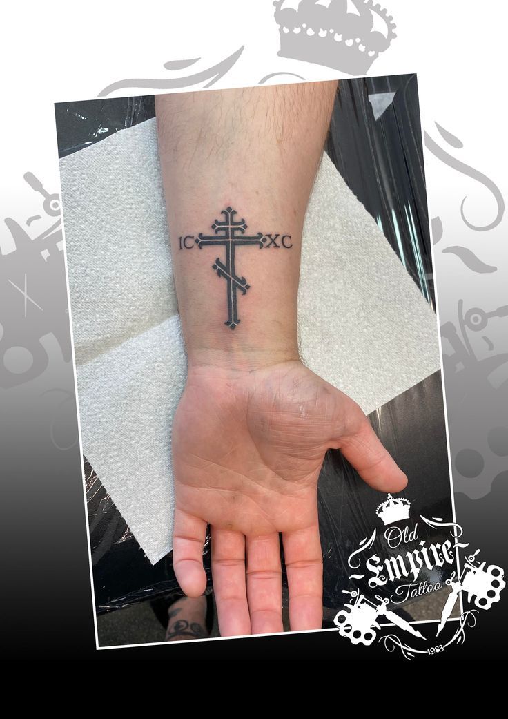 a person with a cross tattoo on their wrist and hand, in front of a white background