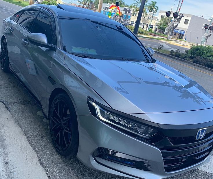 a silver car is parked on the side of the road