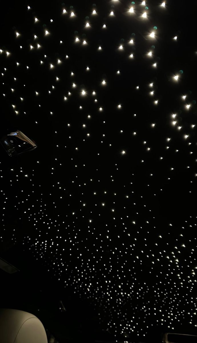 the ceiling is covered with hundreds of white lights in an otherwise black space that appears to be lit up