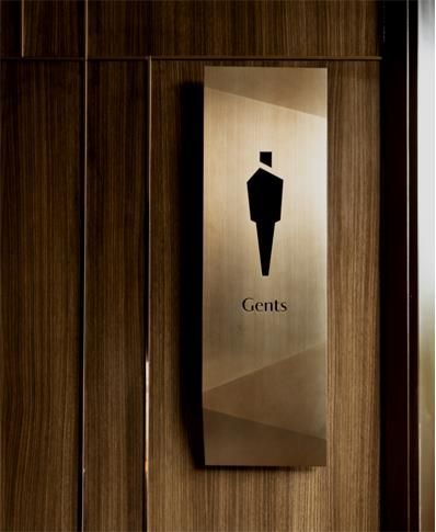 an elevator door sign with the words gents on it and a man in a suit